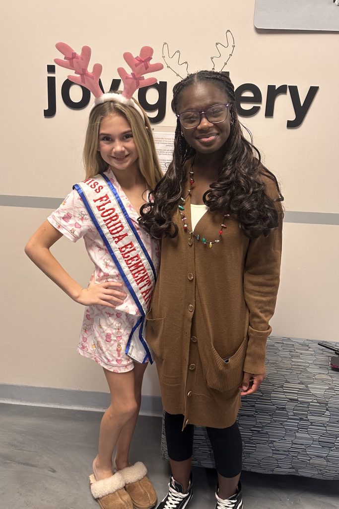 Addie pictured with her Miss Florida Elementary 2026 sash with Ms. Imani, Humane Educator, at the JHS Deck the Howls event.